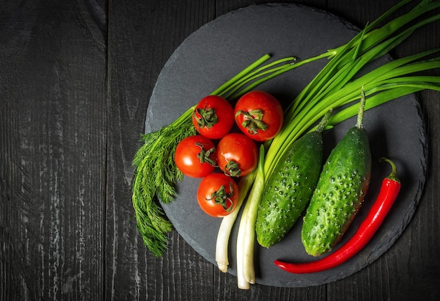 Set di vitamine per insalata di verdure fresche Pomodori rossi e cipolle verdi con cetriolo su un piatto