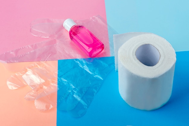 Set igienico di rotolo di carta igienica, guanti di plastica usa e getta e bottiglia con gel disinfettante antisettico. Prodotti per l'igiene. Protezione durante l'epidemia di coronavirus.