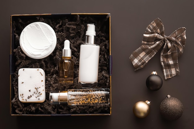 Set regalo di Natale vacanze di Natale pacchetto di abbonamento beauty box e prodotti per la cura della pelle di lusso flatlay cosmetic flat lay su sfondo scuro cosmetici come regalo di vacanza o consegna shopping