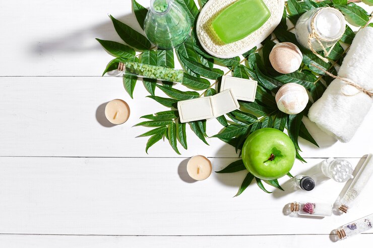 Foto set spa con asciugamano e sapone su fondo di legno bianco con foglie verdi