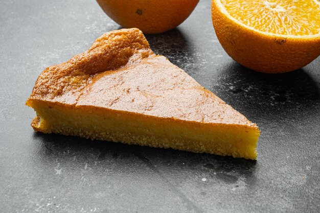 Set torta di polenta all'arancia, su sfondo nero tavolo in pietra scura