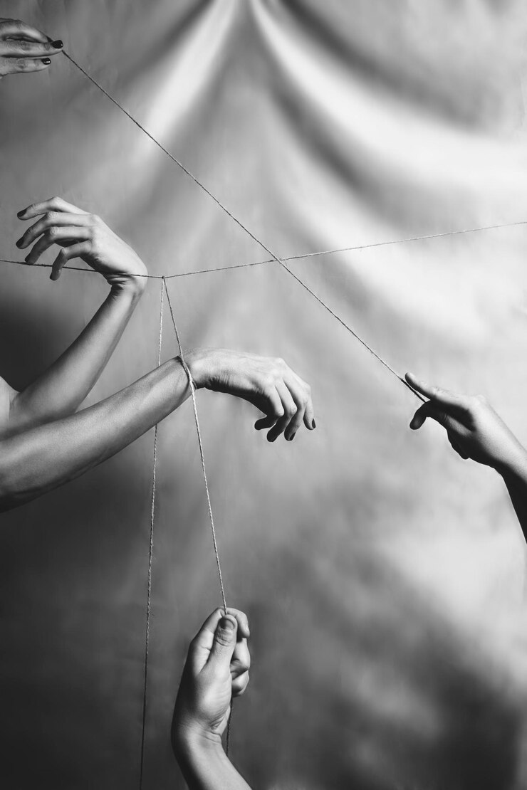 Photo several hands joined and connected through a taut thread black and white union diversity community sisterhood
