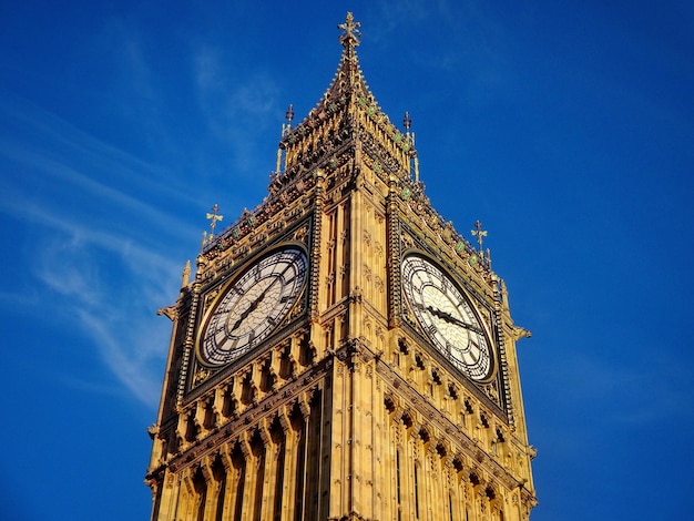 Sezione alta della torre dell'orologio contro il cielo blu