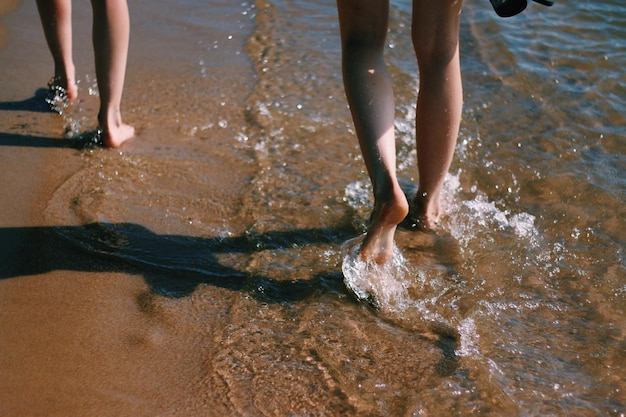 Sezione bassa di donne che camminano sulla riva