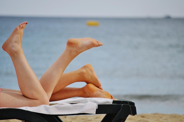 Sezione bassa di donne che si rilassano sulla spiaggia