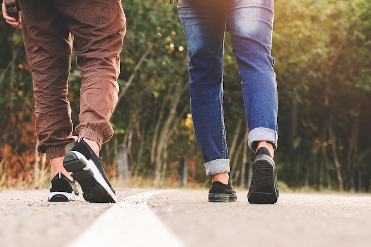 Foto sezione bassa di persone che camminano sulla strada