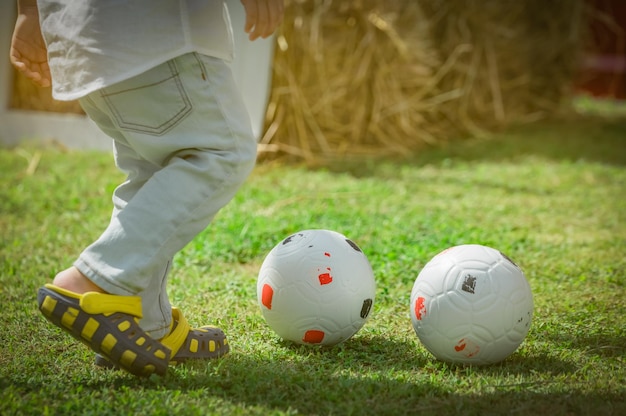 Sezione bassa di un ragazzo che gioca a calcio su un terreno erboso