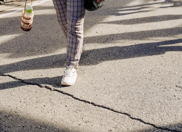 Sezione bassa di un uomo che cammina per strada