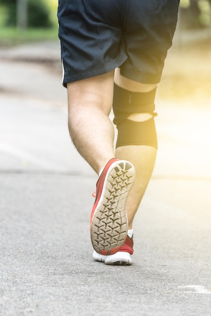 Sezione bassa di un uomo che corre sulla strada
