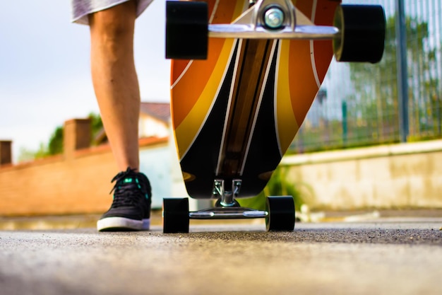 Sezione bassa di un uomo con uno skateboard in strada