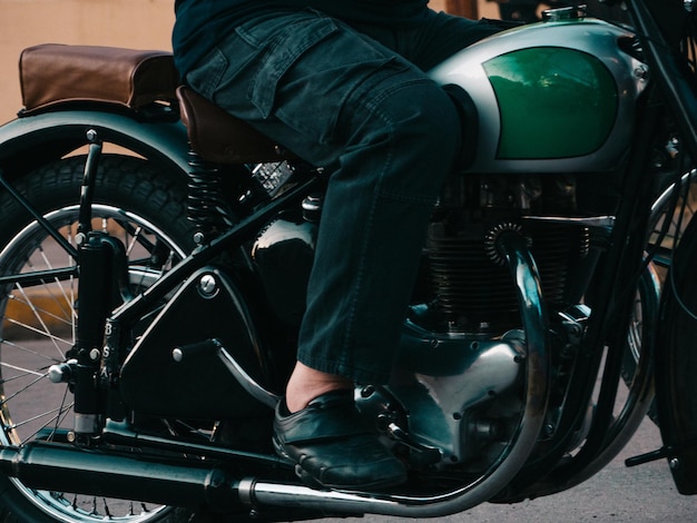 Sezione bassa di un uomo seduto in moto all'aperto