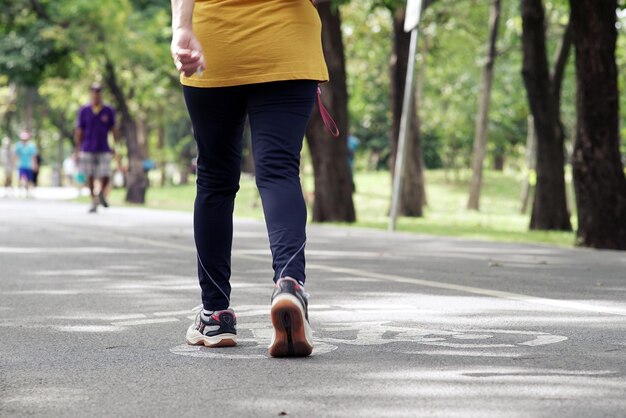 Sezione bassa di una donna che cammina sulla strada al parco