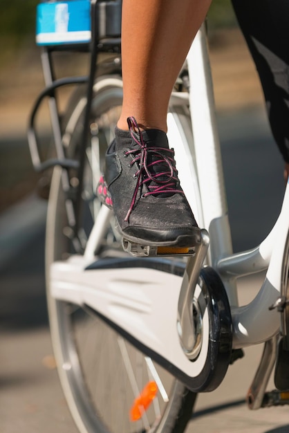 Sezione bassa di una donna con una bicicletta in strada