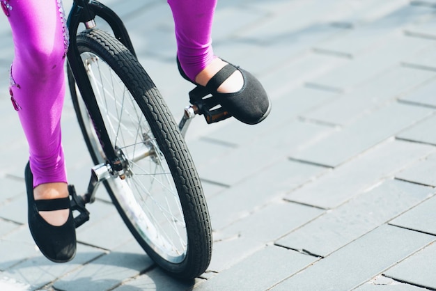 Sezione bassa di una donna in bicicletta per strada