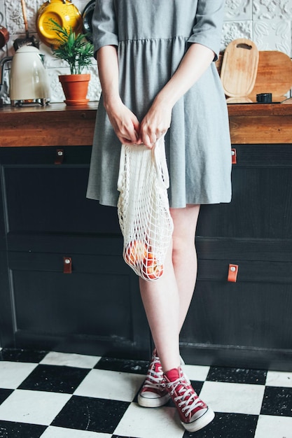 Sezione bassa di una donna in piedi in cucina
