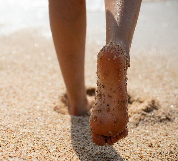 Sezione bassa di una donna in piedi sulla sabbia sulla spiaggia