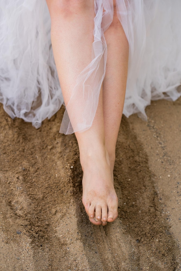 Foto sezione bassa di una donna in piedi sulla spiaggia