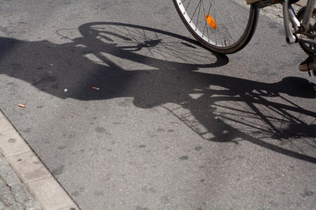 Sezione bassa di una persona con una bicicletta sul pavimento piastrellato