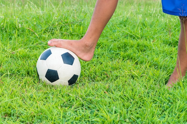 Sezione bassa di una persona con una palla da calcio sull'erba