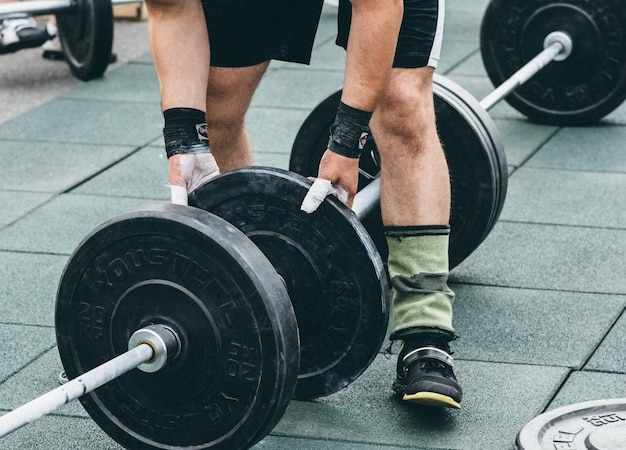 Sezione bassa di una persona in palestra che fa sollevamento pesi