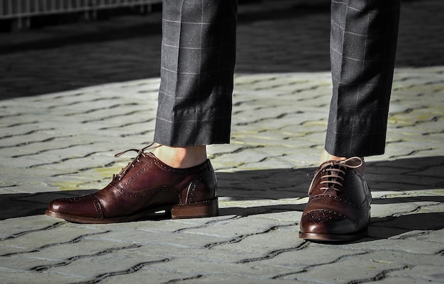 Sezione bassa di uomo che indossa scarpe in piedi sul sentiero