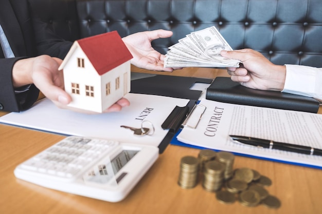 Sezione centrale dell'agente immobiliare che accetta valute cartacee dal cliente in ufficio