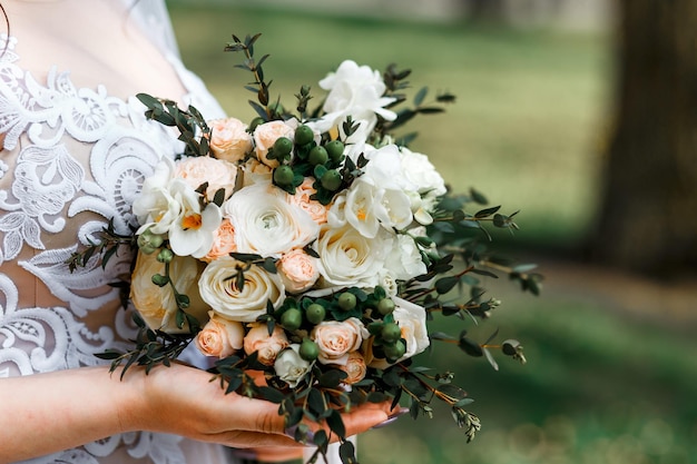 Sezione centrale della sposa che tiene un bouquet di rose