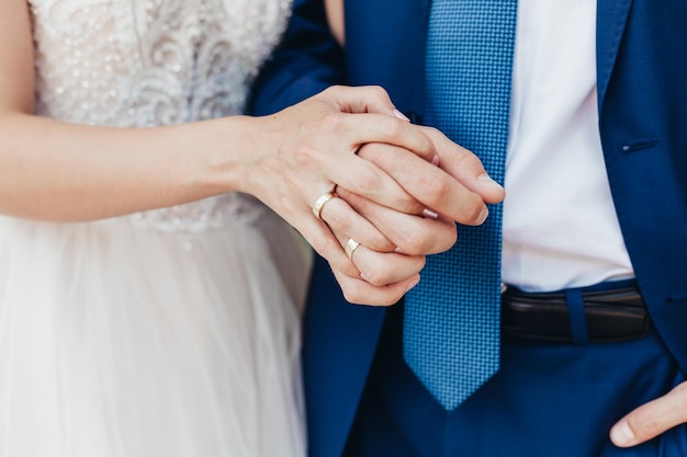 Sezione centrale della sposa e dello sposo che si tengono per mano durante la cerimonia nuziale