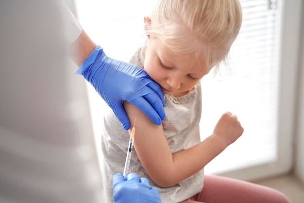 Sezione centrale di un medico che vaccina una ragazza in clinica