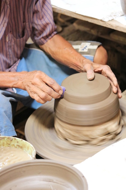 Sezione centrale di un uomo che modella una forma su una ruota di ceramica