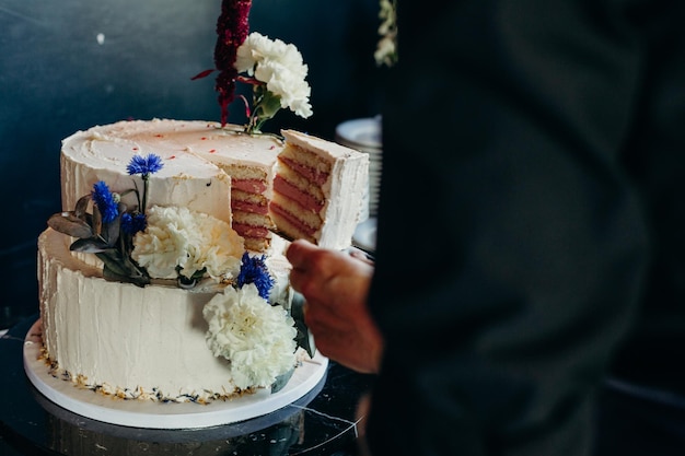 Sezione centrale di un uomo che prende una fetta di torta alla cerimonia nuziale