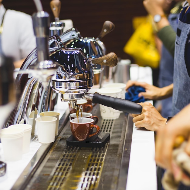Sezione centrale di un uomo che riempie una tazza usa e getta con una bevanda in un caffè