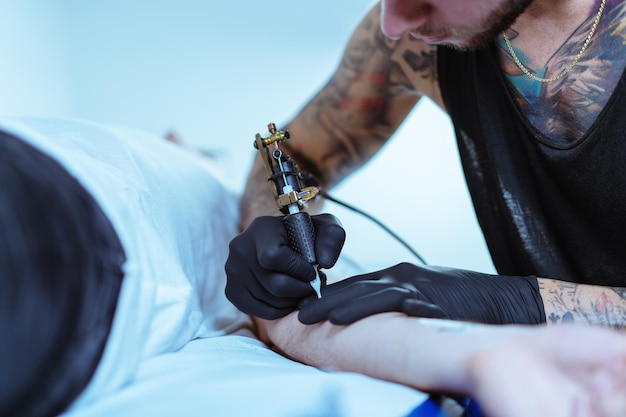 Sezione centrale di un uomo che si tatua sulla mano di un cliente.