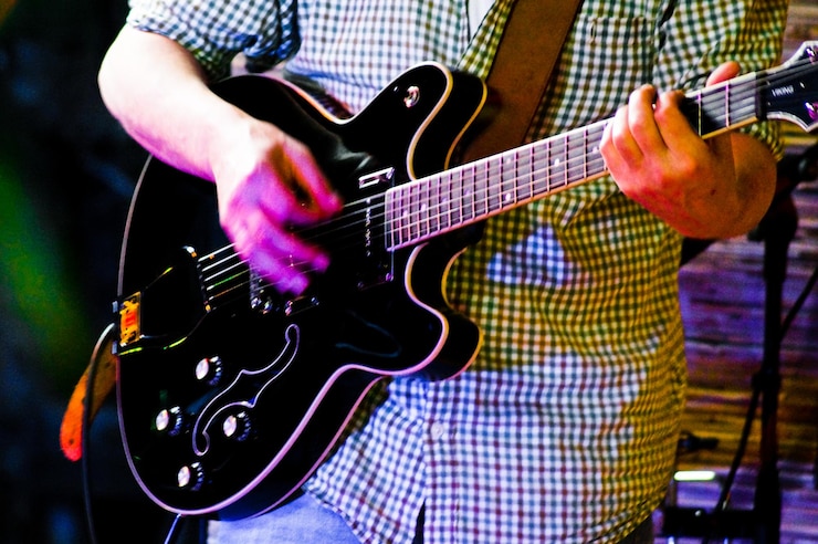 Foto sezione centrale di un uomo che suona la chitarra