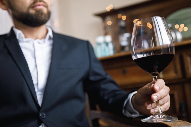 Sezione centrale di un uomo d'affari che tiene un bicchiere di vino