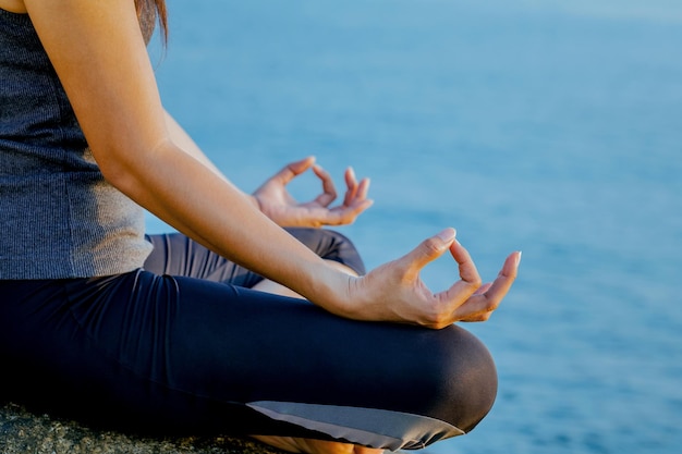 Sezione centrale di una donna che pratica yoga sulla spiaggia