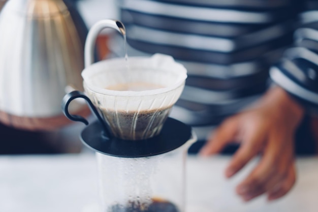 Sezione centrale di una donna che prepara il caffè sul tavolo in un caffè