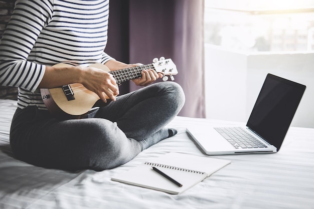 Sezione centrale di una donna che suona la chitarra a casa