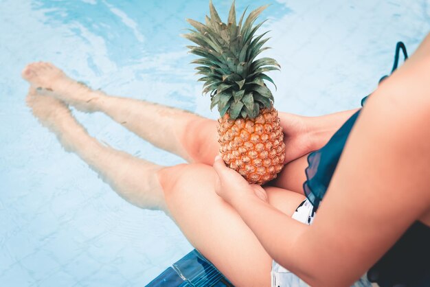 Sezione centrale di una donna che tiene il gelato in piscina