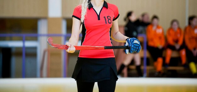 Sezione centrale di una donna che tiene un bastone da hockey mentre si trova in tribunale