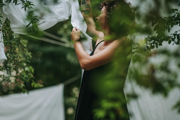 Sezione centrale di una donna che tiene un ombrello in piedi vicino alle piante