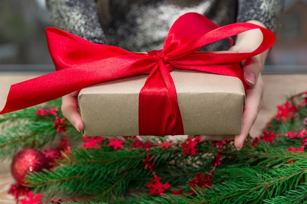 Sezione centrale di una donna che tiene un regalo di Natale a tavola