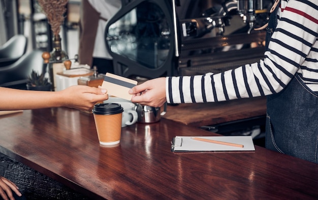 Sezione centrale di una donna che tiene una tazza di caffè sul tavolo