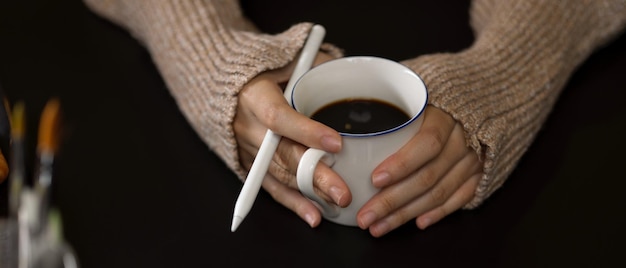 Sezione centrale di una donna che tiene una tazza di caffè