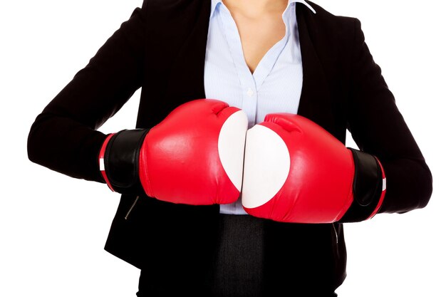 Sezione centrale di una donna d'affari che indossa guanti da boxe su uno sfondo bianco