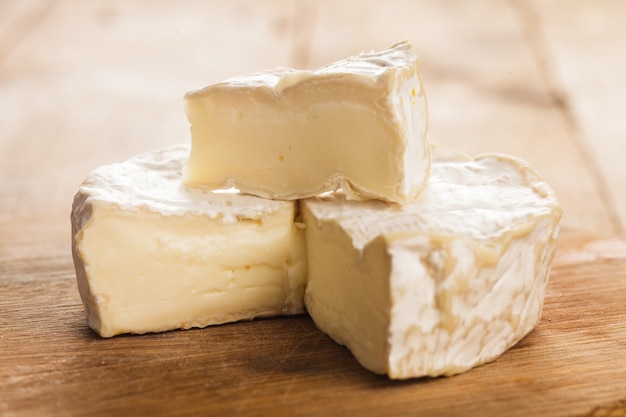 Sezione di formaggio Camembert sulla tavola di legno. Immagine macro