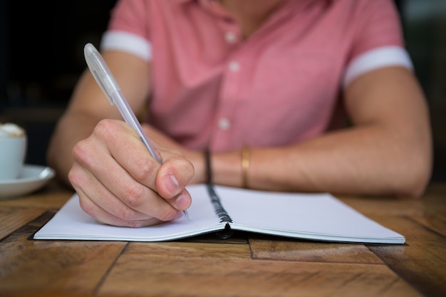 Sezione mediana dell'uomo che scrive nel diario a tavola