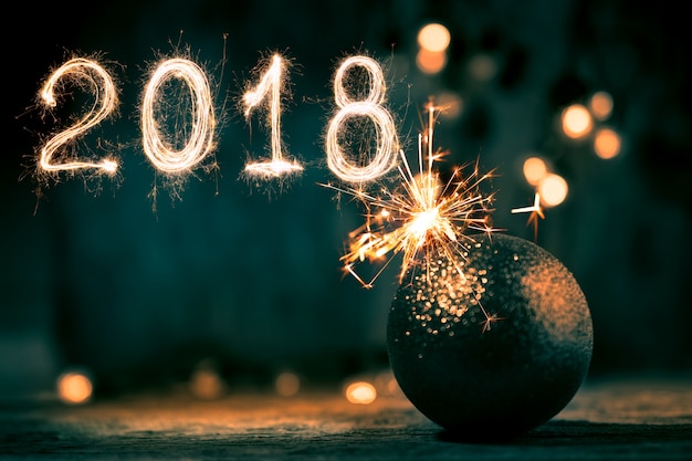 Sfera astratta di natale con 2018 scritto con i fuochi d&#39;artificio delle scintille.