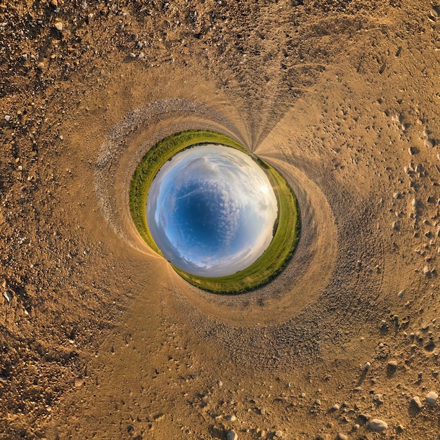 Sfera blu piccolo pianeta all'interno della strada sterrata o dello sfondo del campo