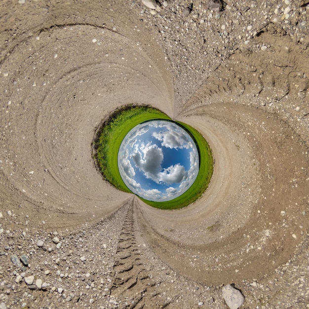 Sfera di buco blu piccolo pianeta all'interno di sabbia di ghiaia sfondo di telaio rotondo